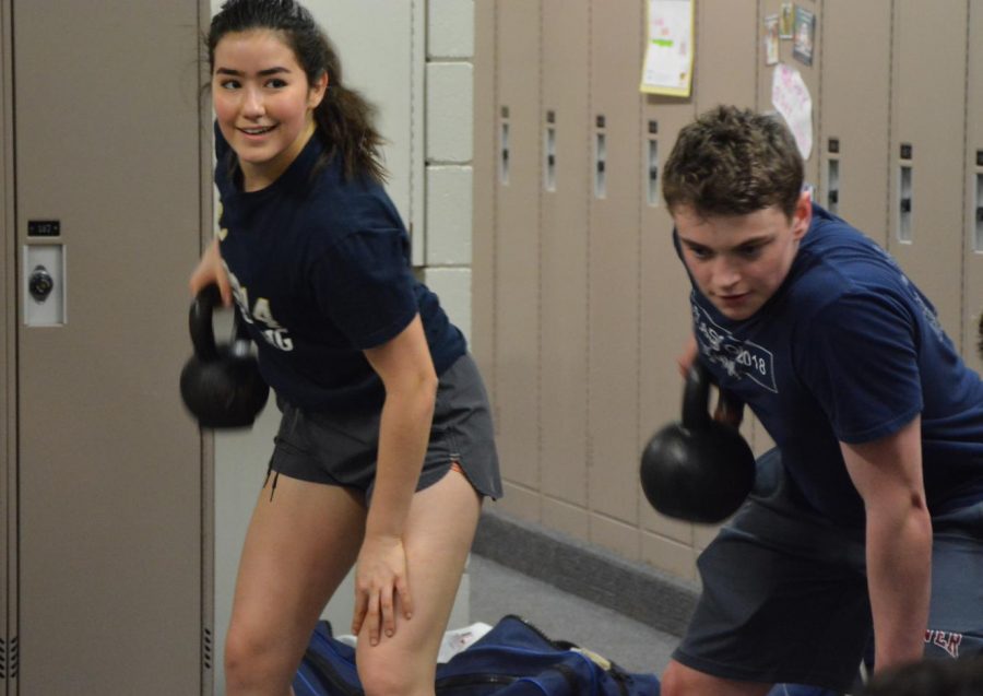 Captain Numi Katz lawnmowing with a dumbell for strength training.