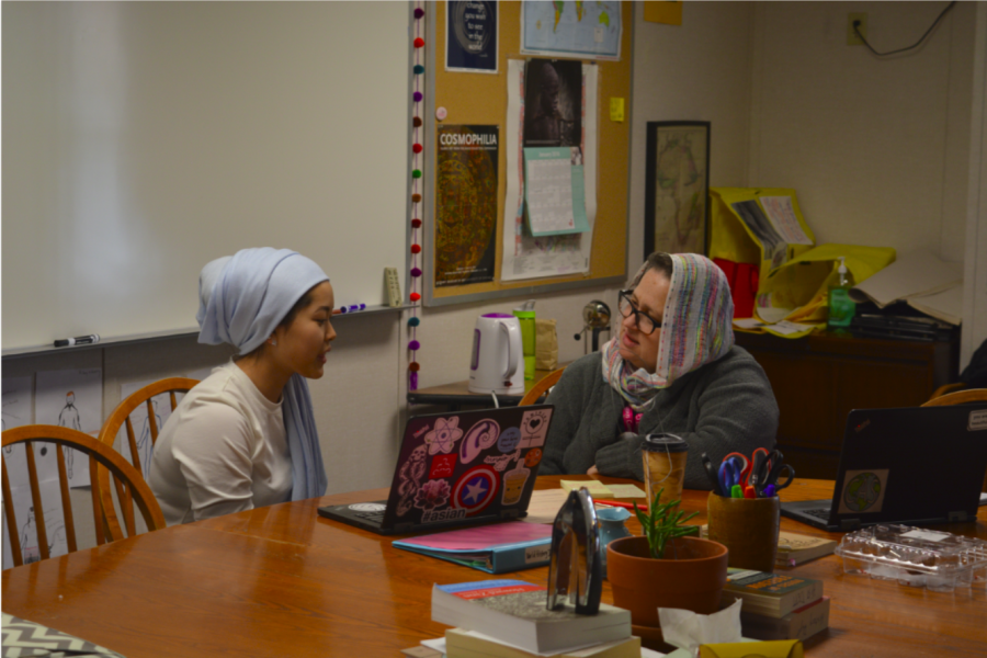 US history teacher Molly Ward and junior Elea Besse go over her history agenda in a hijab. This is the third annual Hijab Day organized by the Muslim Student Alliance.