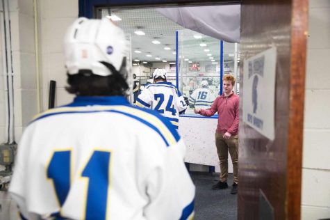 Stolpestad cheers on the team before the start of a period. "I started at the beginning of the season because some of the guys on the team said I should do it, and that it would be fun," Stolpestad said.