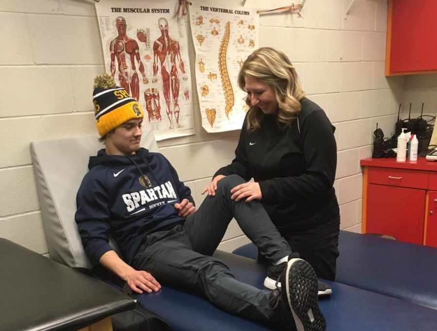 HOLD STILL. Upper School athletic trainer Lauren Kijewski tends to a student. I like working with the kids. I love talking with them and hearing about their days... They always come in and keep you laughing, Kijewski said. 