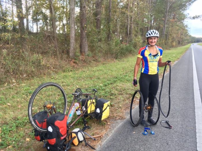 Alum+Ariana+Amini+%2813%29+poses+for+a+photo+next+to+her+bike+as+she+fixes+a+flat+tire.+Amini+is+part+of+an+all-female+team+biking+across+the+country+to+raise+awareness+for+protection+of+U.S.+public+lands.+%E2%80%9CNow+that+I%E2%80%99ve+immersed+myself+more+in+the+issue+I%E2%80%99ve+realized+how+convoluted+it+is%2C+and+how+many+perspectives+there+are%2C+and+aspects+that+affect+every+element+of+environmentalism%2C+Amini+said.