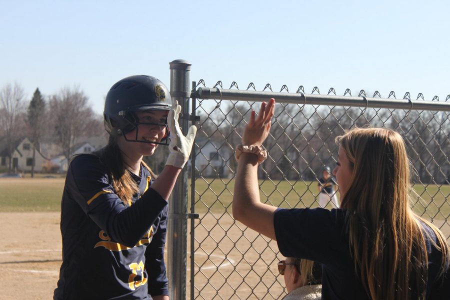 Sophomore Kathleen Bishop high fives senior Sophia Rose after scoring a run. Its been a lot easier to get close to everyone on the team because its so small. Bishop said.