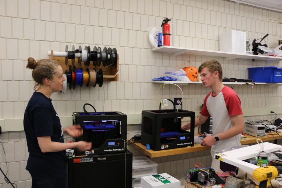 Director of Computer Science and Engineering Kate Lockwood teaching a student how to use the 3D printer. 