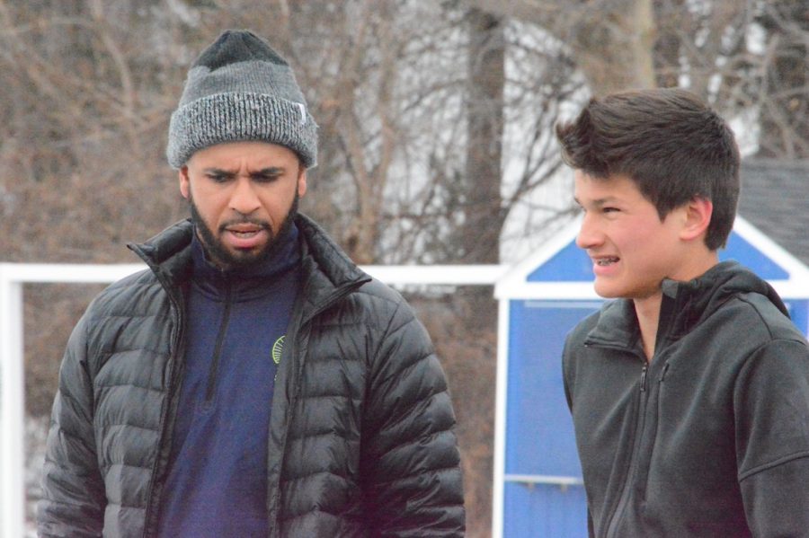 Track coach Kellan Minter works with a member of the boys track team in the early part of the season. Minter hopes he can be the same good influence on his team that his coaches were on him.
 “I learned more from [my coaches] about being a good person than I did about sports in general,” he said. 