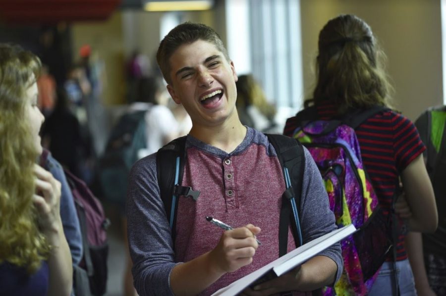 Ninth grader Jax Wittenberg laughs as he signs a yearbook. 