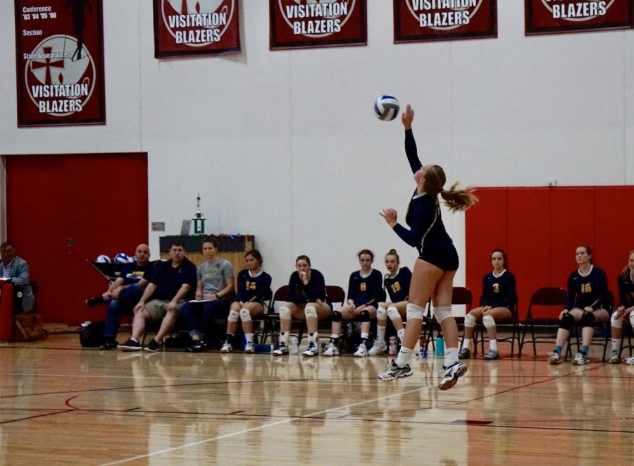 Junior Sydney Therien serves a jump serve against Visitation. 