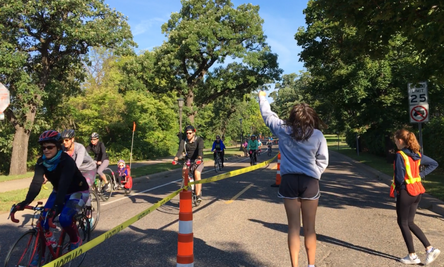 Students cheer on bikers biking along the Mississippi River at the Bike Classic.