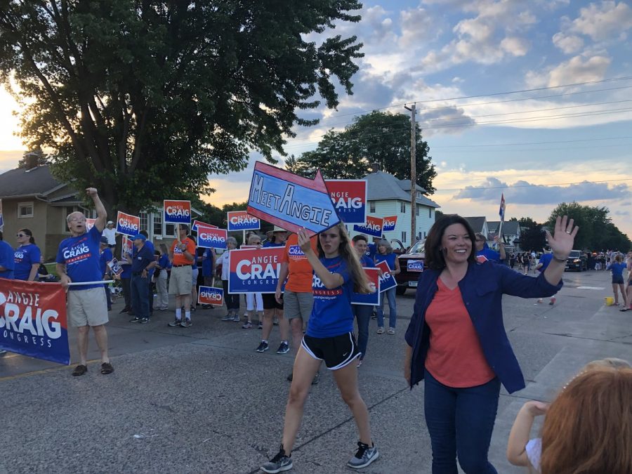 Kaia Larsen holds a sign pointing toward candidate Angie Craig at a parade this summer. “Tell people to get out to vote on November 6. Register to vote, thats really important, [and don’t forget to vote and] use your voice,” Larsen said.