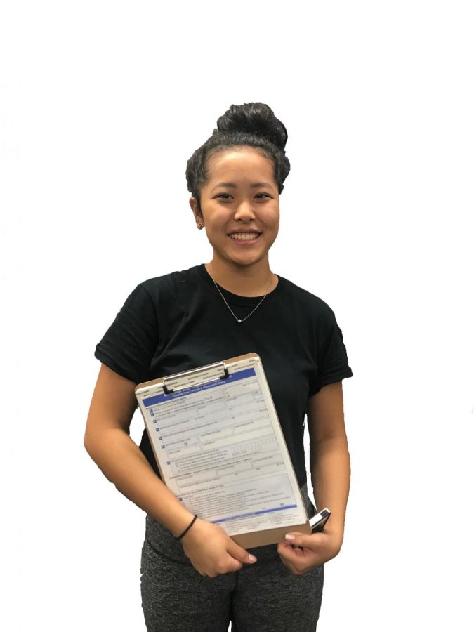 Senior Elea Besse holds voter registration papers.