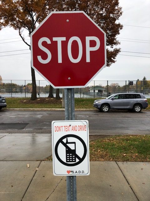 A sign made by SADD at the Huss Center's parking lot exit reminds people to not text and drive.