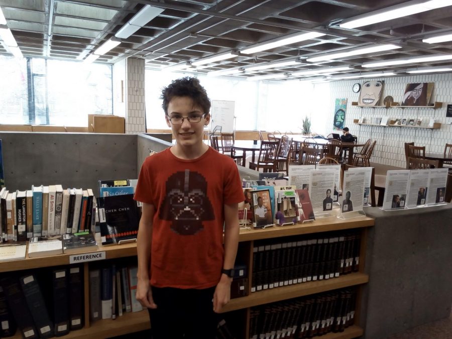 Sophomore Raffi Barocas stands in front of the librarys LGBTQ+ book display.