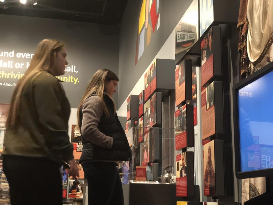 As videos play in the first room of the exhibit, seniors Kenzie Giese and Bailey Donovan read the anecdotes floating on the walls. 