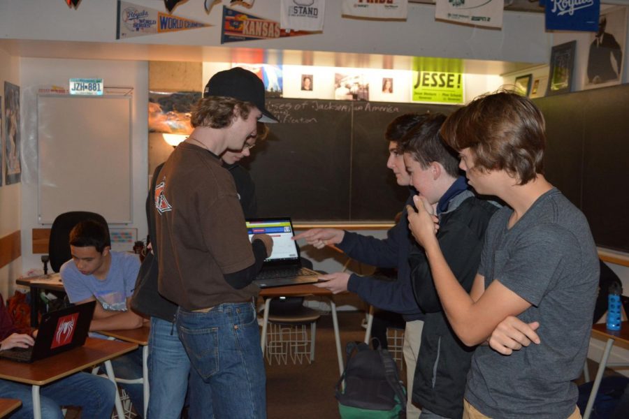 A Business Club meeting from 2018, where students gather closely around a computer