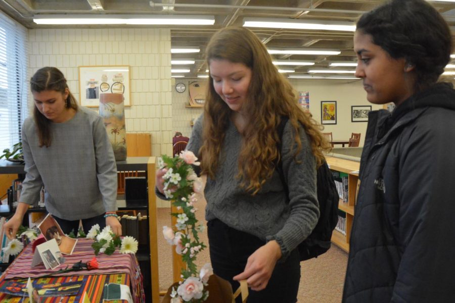 Senior Isabel Saavedra-Weis and Sophomores Pilar Saavedra-Weis and Aman Rahman put the final touches on the offrenda. 