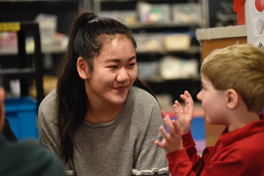 Senior Maya Orey chats with her kindergarten buddy.