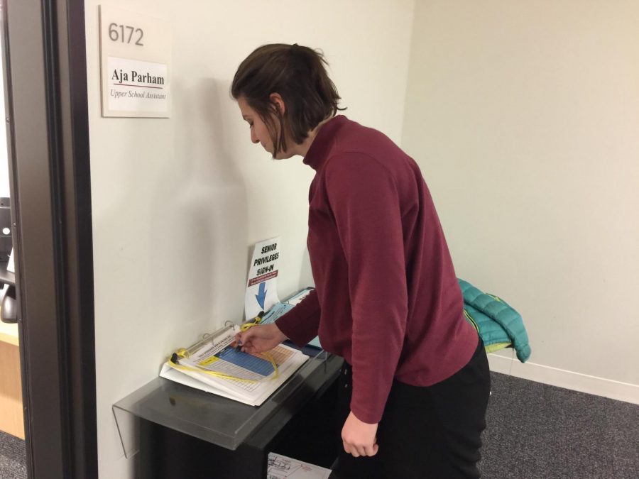 Senior Jenny Sogin signs in at the US office. 