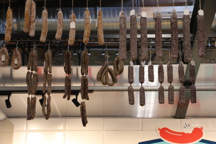 Dangling sausages hang above Knack, a German-styled meat shop.