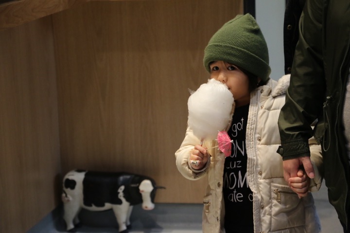 A girl enjoys her cotton candy from Spinning Wylde at Keg and Case Seventh Street Market.