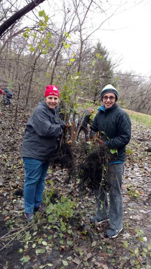 Advisor Mary Lincoln and PEP President Iris Shaker-Check holding the invasive buck thorn roots that plague Crosby Farm Park.