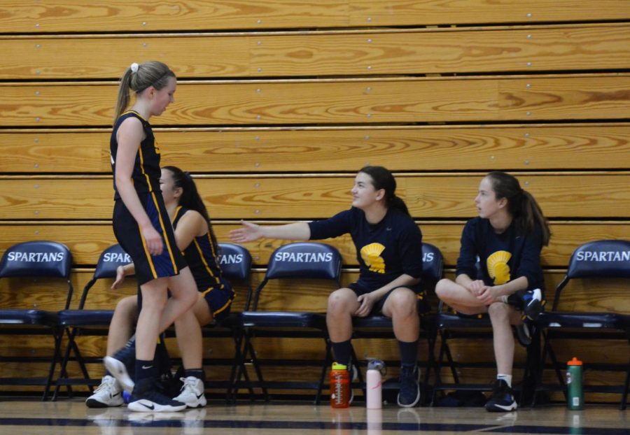 Junior Abby Hedberg is greeted with words of encouragement from her teammates as she comes off the court. 