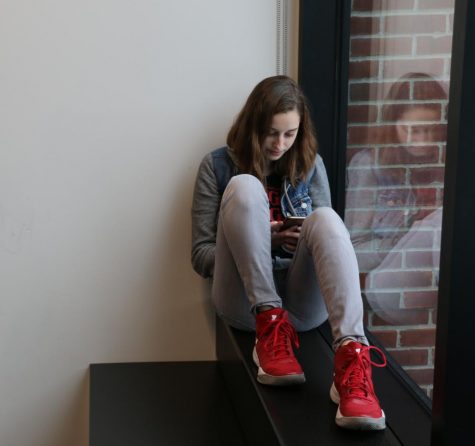 Junior Nina Smetana looks at her phone in the Schilling Center. Personally, I like to interact with people. I have had a lot of friends that are across the country, and I find it hard to constantly keep in touch with them because I’m really quite bad at long distance communication,she said.