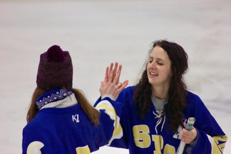 US Science teacher Christine Schwichtenberg high fives US Fitness teacher  Cari Jo Anderson after she played in the shoot the puck challenge. 