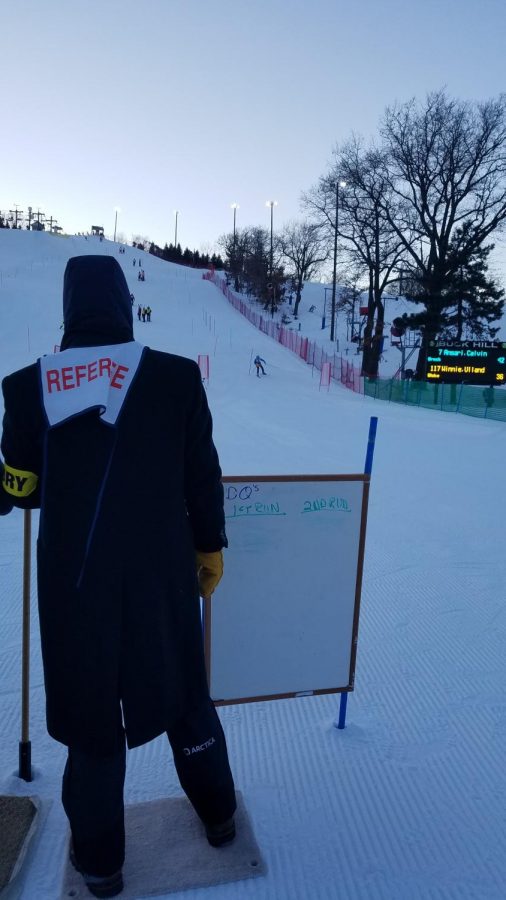 A race timer looks on as a racer completes their run.