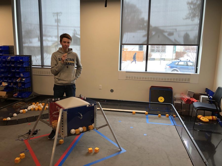 Sophomore John Hall stands in the Robotics room where the team practices using their robot.