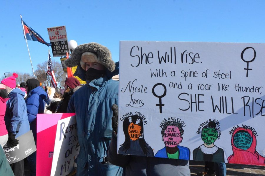 Marches hold signs and gather in front of the Minnesota State Capital to listen to speakers at the third annual Womens March. 