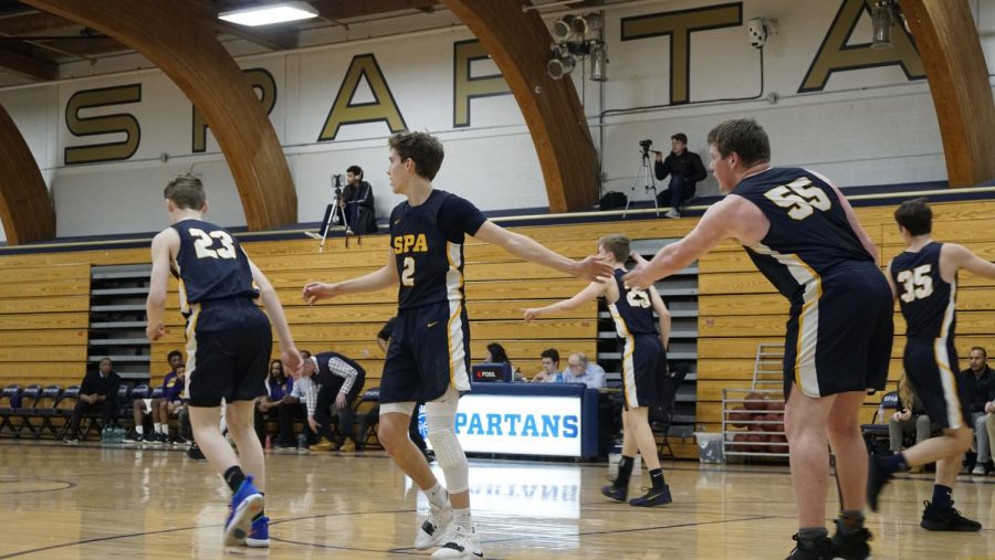 Senior Will Christakos high-fives teammate Ryan Moore after a play.