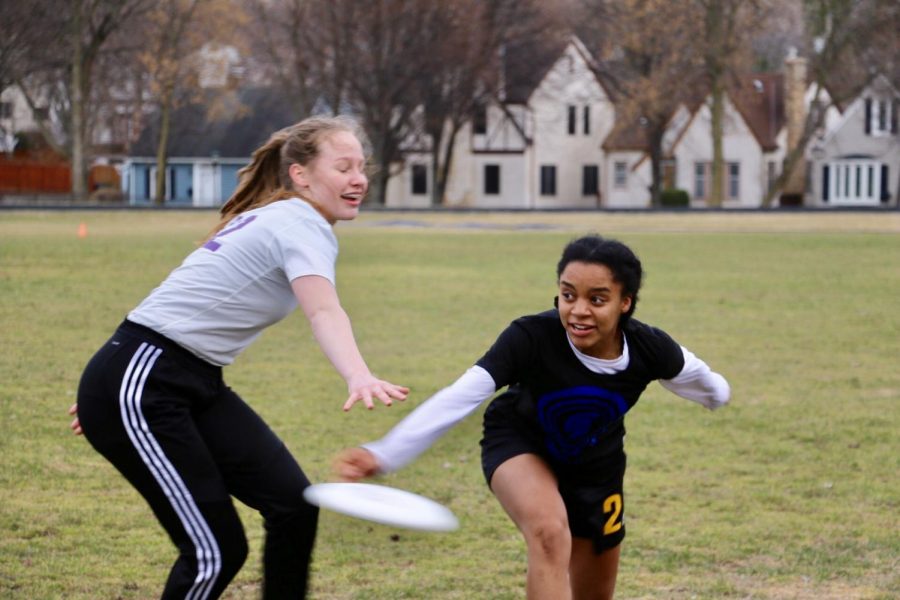 Senior and captain Rachael Johnson passes the frisbee against Cretin defender at the Girls Ultimate game against Cretin on Apr. 9 on Historic Lang Field. 