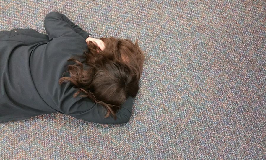 Senior Eliza Reedy naps on the floor of the Lower Library during the last Monday of her high school career. 