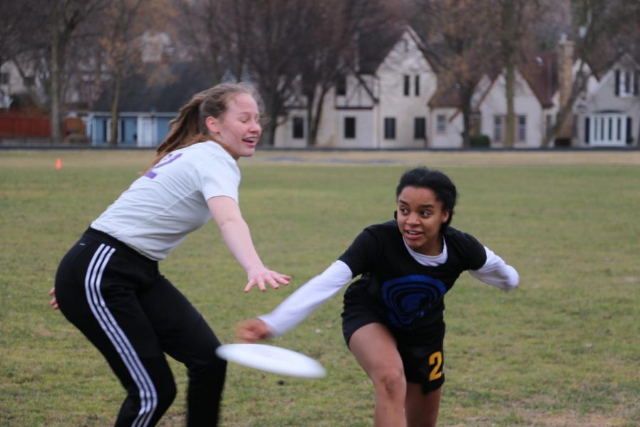 Senior and captain Rachael Johnson passes the frisbee against Cretin defender at the Girls Ultimate game against Cretin on Apr. 9 on Historic Lang Field. 