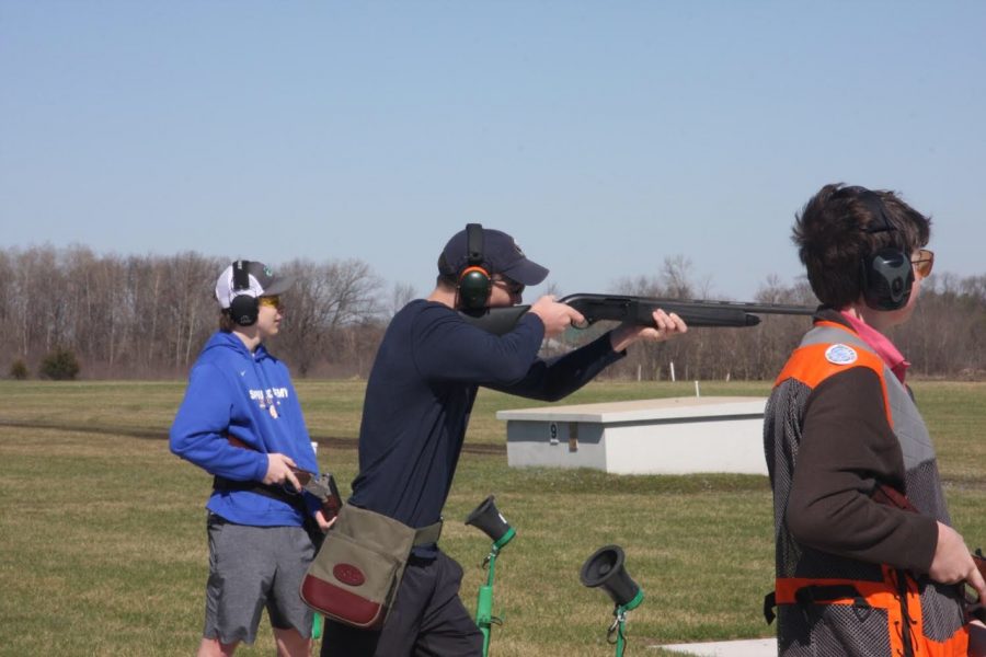 Junior Eric Bottern (middle) aims for a clay pigeon in his first round of the day.