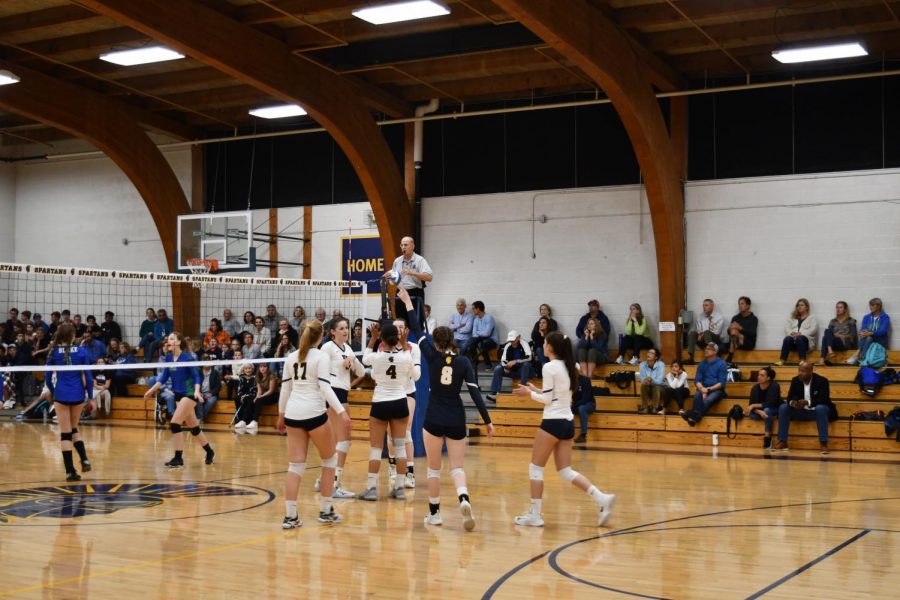 Girls Varsity Volleyball celebrates together after scoring a point against Blake.  “When we score a point we usually come together and celebrate the point. senior Kathleen Bishop said.  Along with the volleyball team, the student section celebrates their success. 