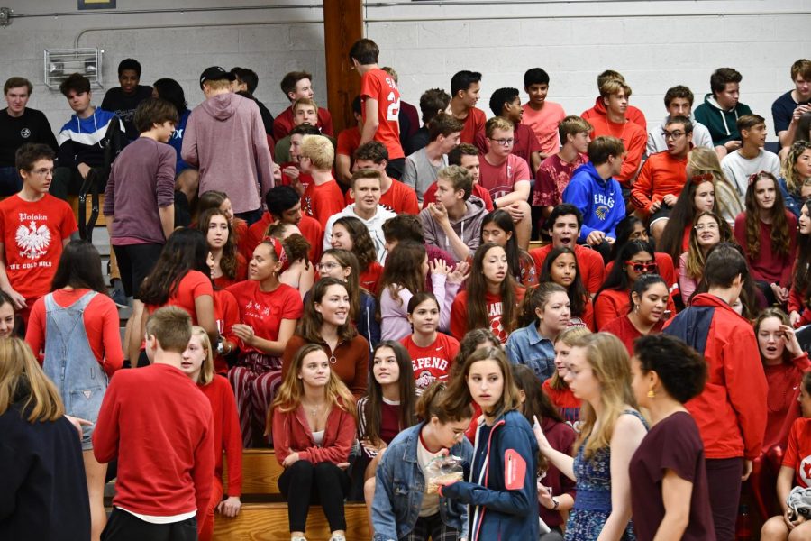 Juniors, wearing red, talk among one another as they wait for the assembly to commence. 