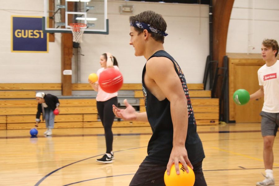 Senior Will Rathmanner tosses a ball in the air as he faces his opponents in the dodgeball tournament.