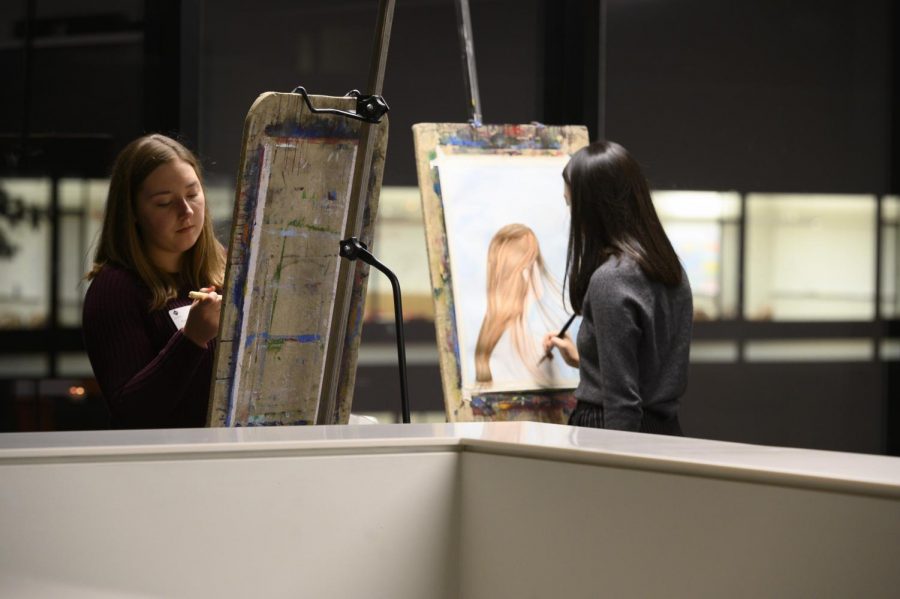 Seniors Ashley Su and Celeste Parke-Reimer work on their paintings in upper Schilling. I feel like it was less of a showcase and more of me getting time to do something I like, Su said.