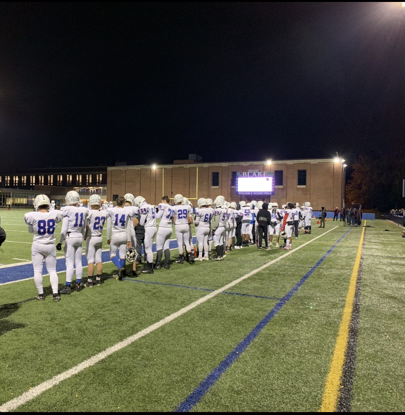 The rest of the team stands on the sidelines and watches their teammates on the field.