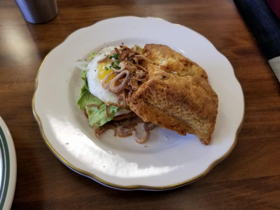 The avocado biscuit sandwich elevated avocado toast by adding a sunny-side-up egg, lime cured onions, roasted serrano mayo, and crispy shallots.