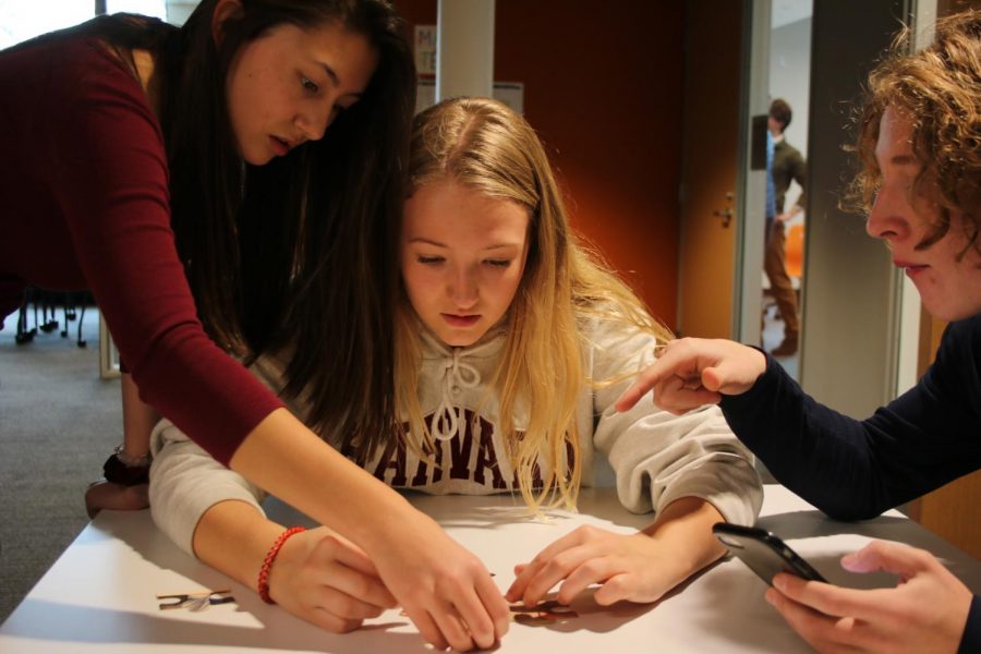 Sophomores Esther Allen, Sarina Charpentier, and Judah Thomas work together to piece together the last hint.