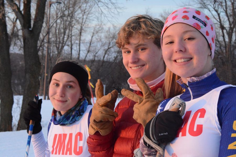 Captains Maddy Breton and Lauren Dieperink and senior Henrik Schleisman pose for a photo as they wait for their race to start.