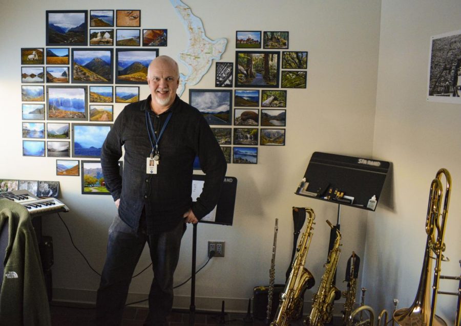 Randy Reid stands in his office, surrounded by many brass instruments. 