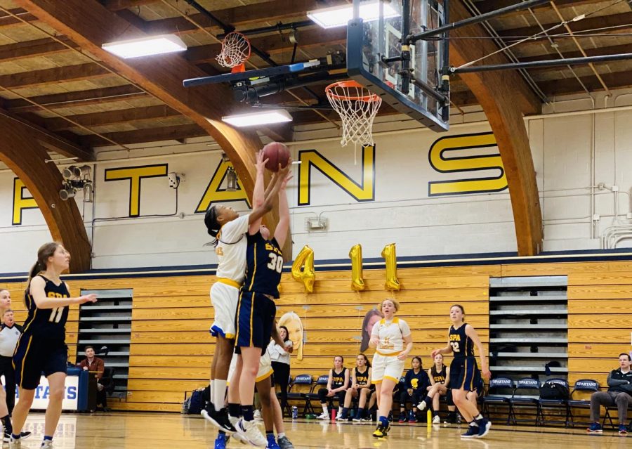 9th grader Lindsay Browne goes for a lay-up, while her opponent tries to block her.