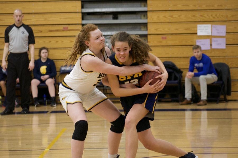 Junior Gabriella Thompson fighting for the ball against Breck