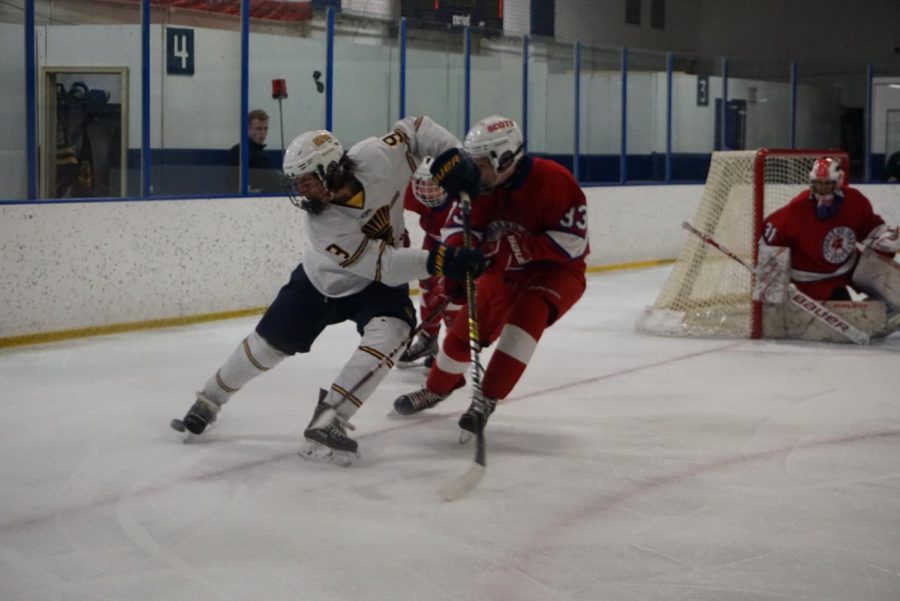 Ninth-grader George Peltier blocks a Highland player from grabbing the puck. 