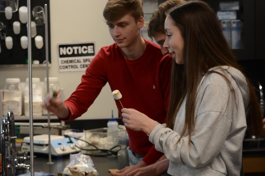 Juniors Adam Holod, Jonas Bray, and Julia Baron share a Bunsen burner. I really like smores, it makes me think of my childhood when I used to make [them] all the time, Holod said.