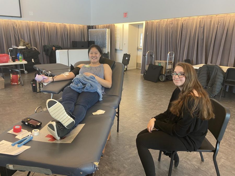 Junior Adeline DeHarpporte accompanies her friend junior Anja Trierweiler who getting her blood drawn for the first time.