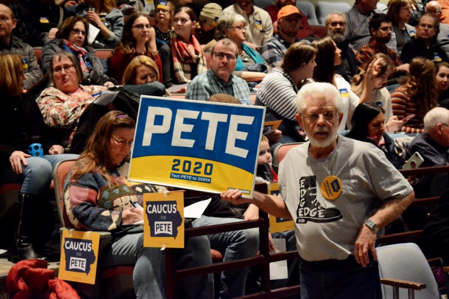 A Buttigieg campaign precinct member holds up a sign at Decorah High School, the site of a caucus.