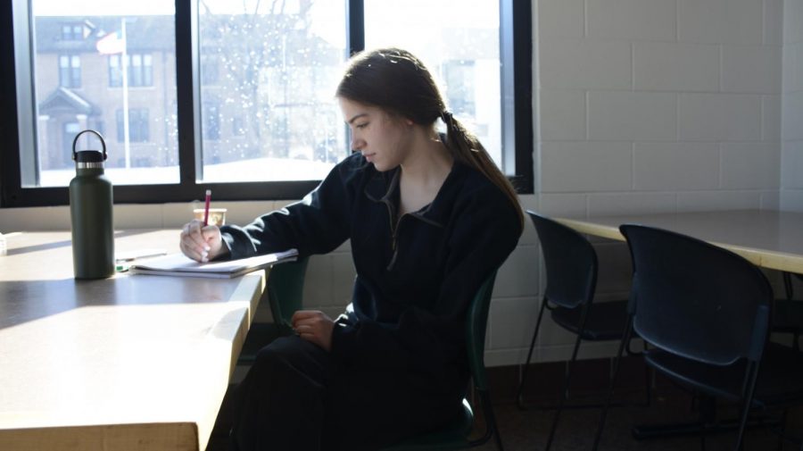 Zelda Harmoning sits in the lunch room while journaling about her day.